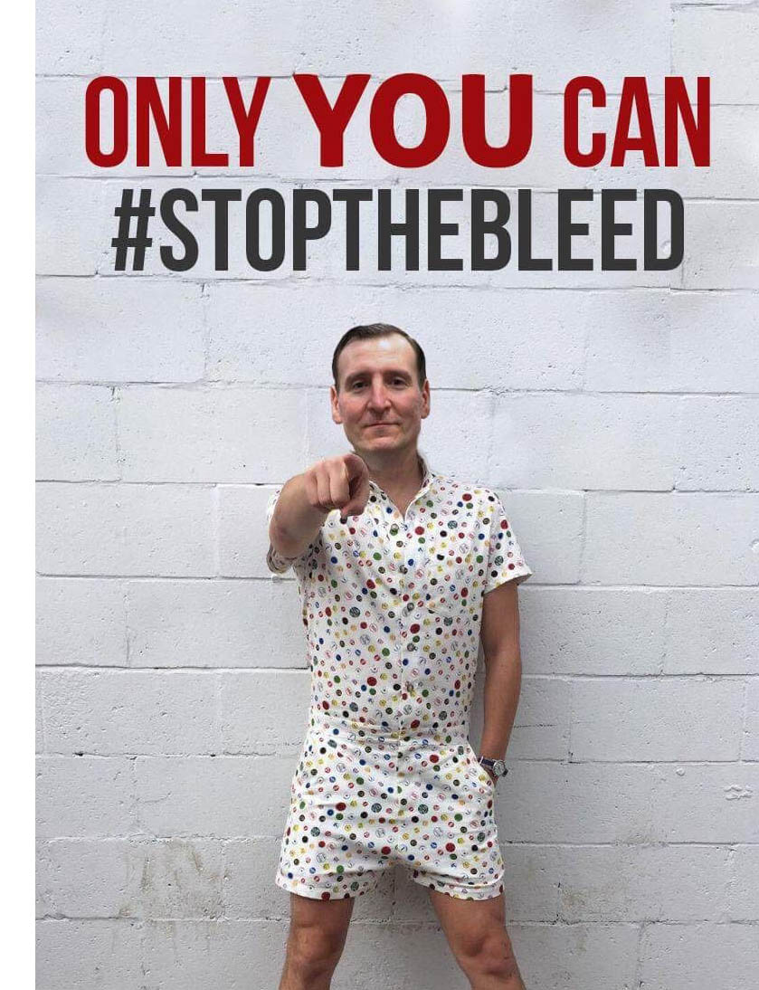 Man posing with the meme that the National Stop the Bleed Day team created to promote the event