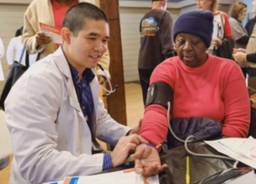 Joe Hwang taking a patient's blood pressure